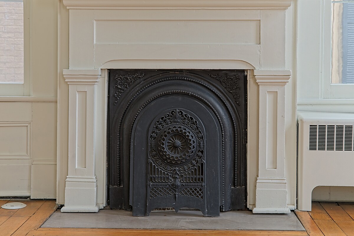 Original cast-iron fireplace with decorative surround and white mantel