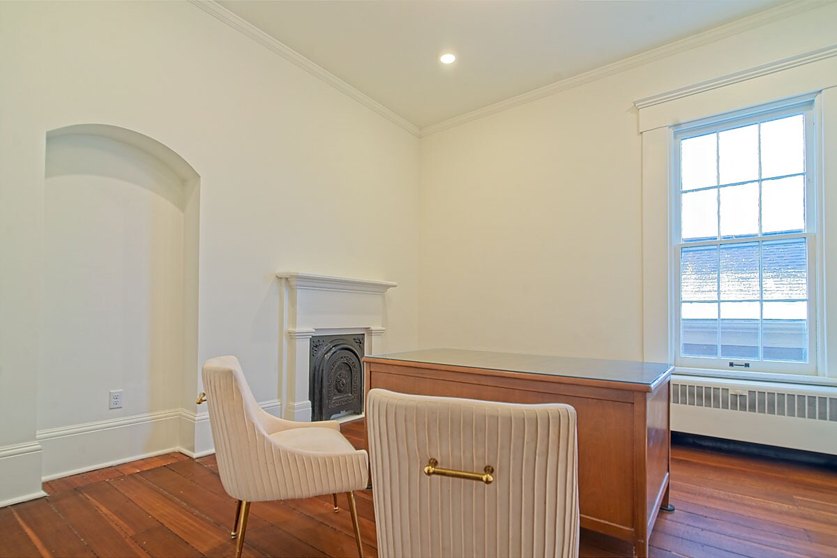 Private office nook with desk, accent chair, fireplace, and natural light