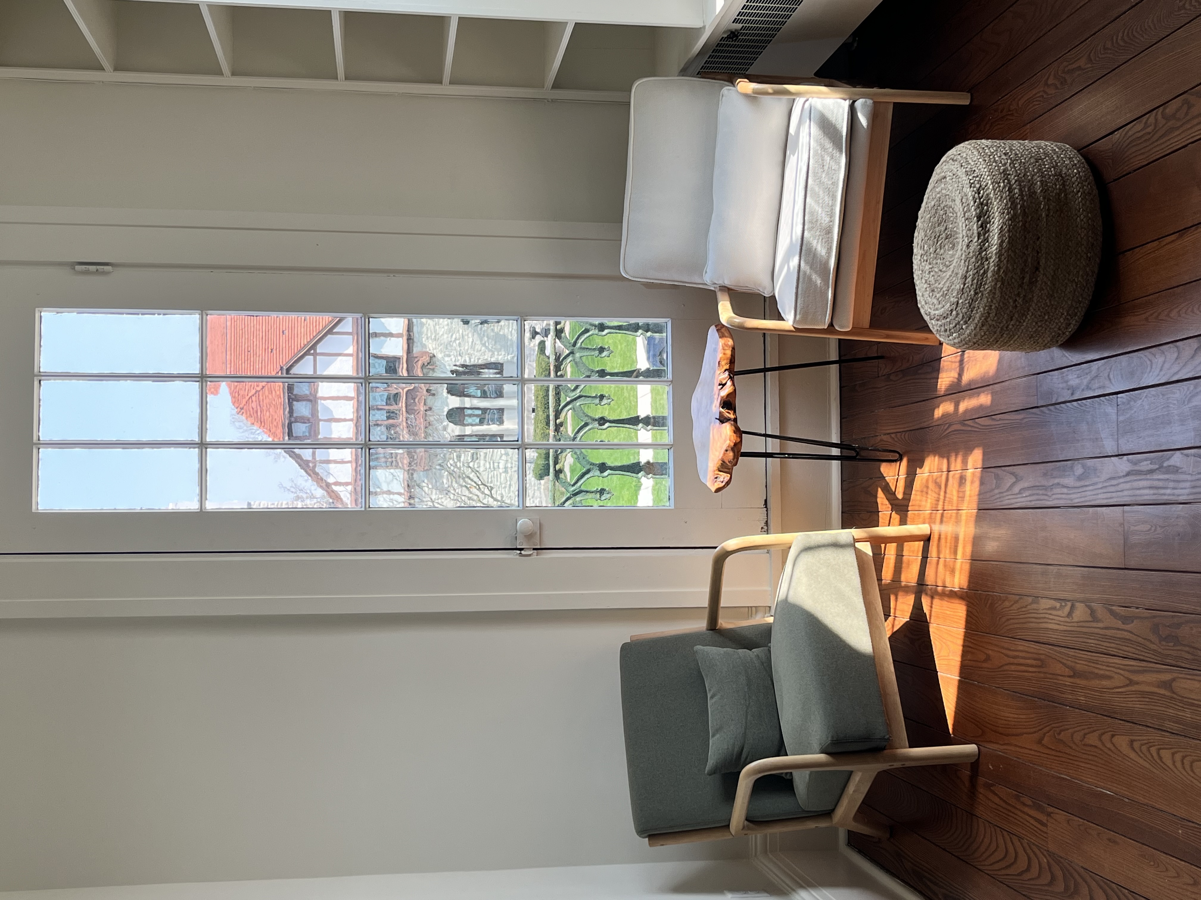 Lounge seating area with large windows and natural light, view of downtown Troy